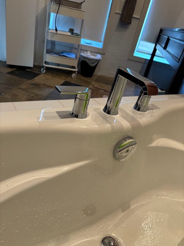Modern chrome tub-deck faucet set installed on a bathtub